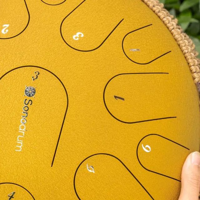 Close-up of a gold tongue drum with numbers on the tongues